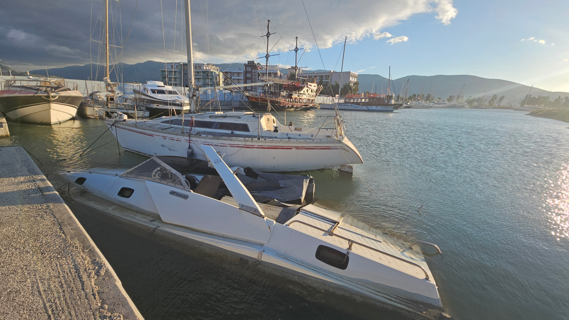 Existing waterfront. Boats currently moored within the basin, including vessels in visibly deteriorated condition.